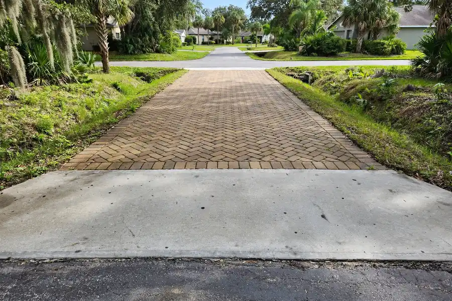Paver driveway meeting a concrete apron at the street