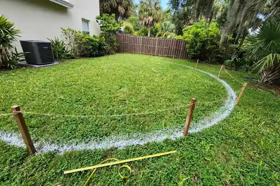 Patio layout marked on a lawn with paint and stakes before building