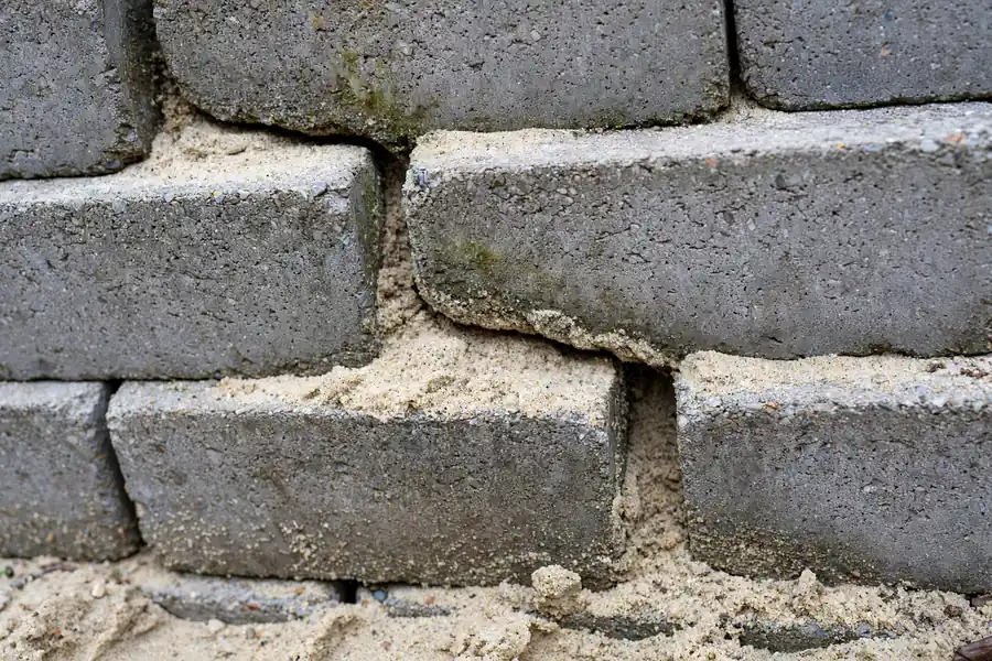 Close-up of a crack running through retaining wall blocks