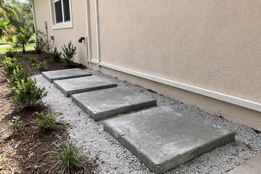 Stepping stones set in gravel along the side of a house